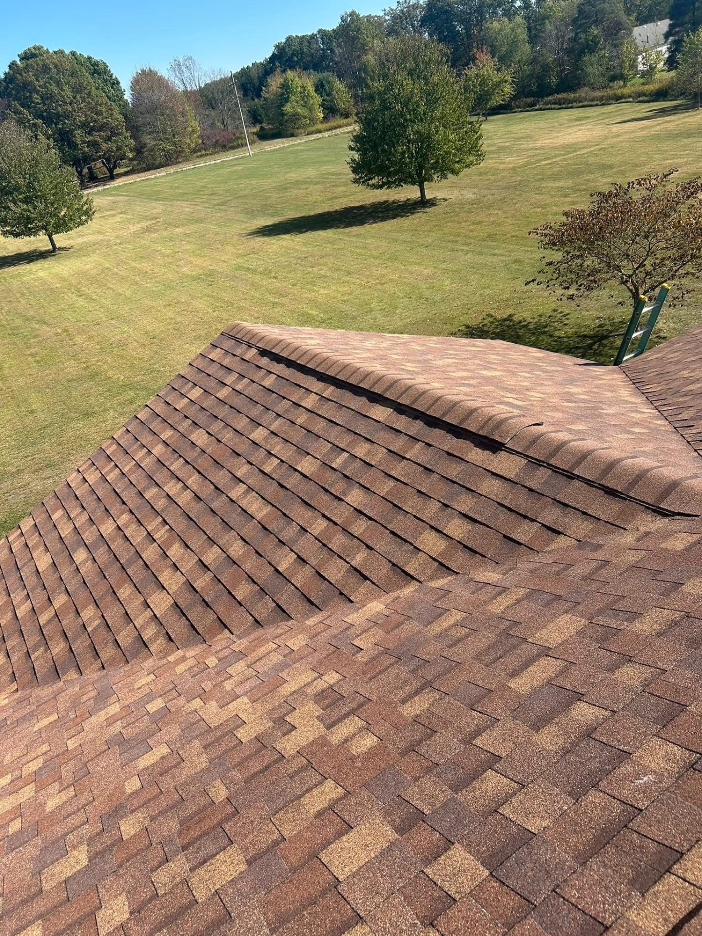 Architectural shingle roof installation overlooking open field