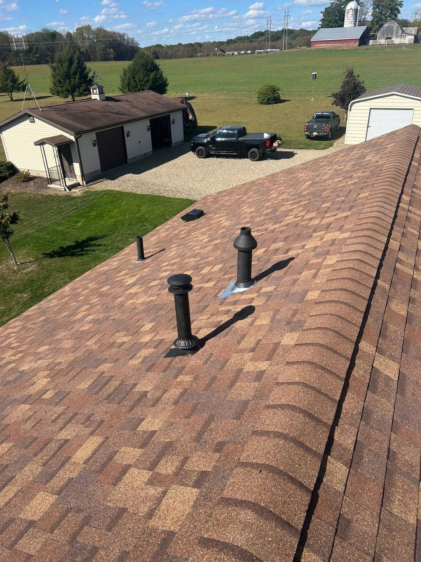 Shingle roof with new vent boots and pipe flashing on a farm property